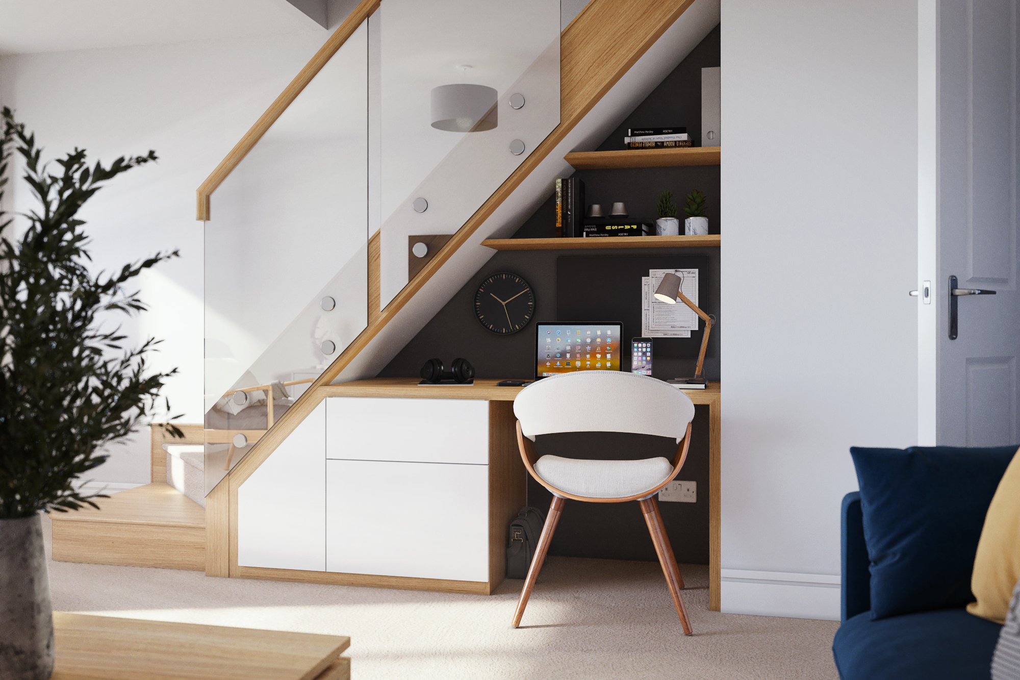 A compact desk complete with in-built shelving underneath a modern staircase