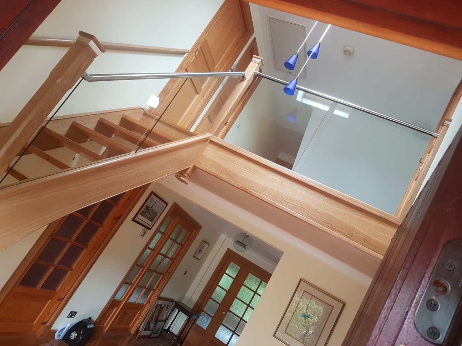 Interior staircase with wooden railings and doors.