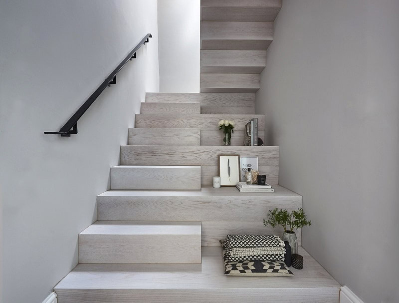 Light wooden stairs with decor and plants.