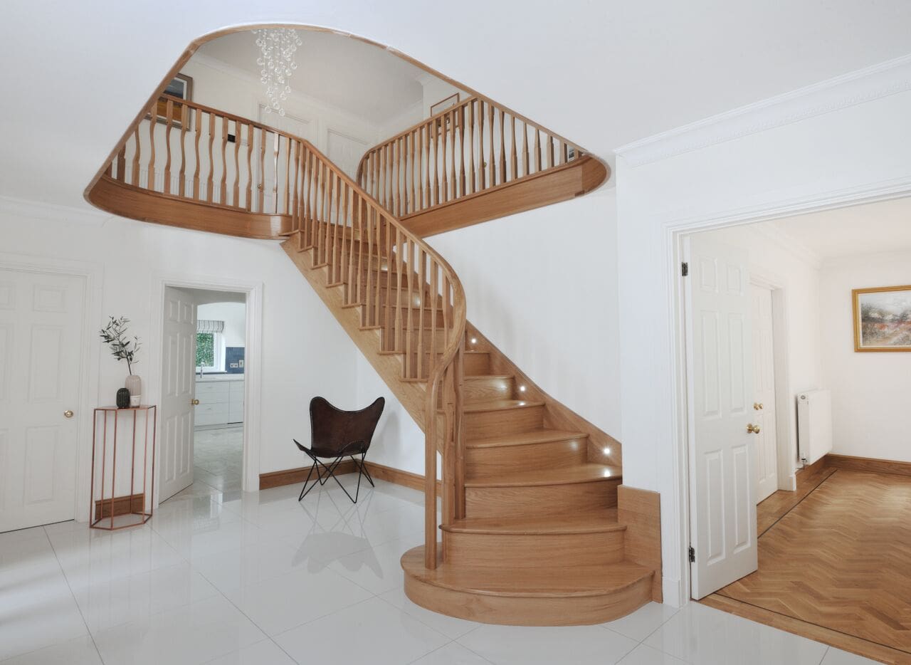 Wooden spiral staircase in modern entryway.
