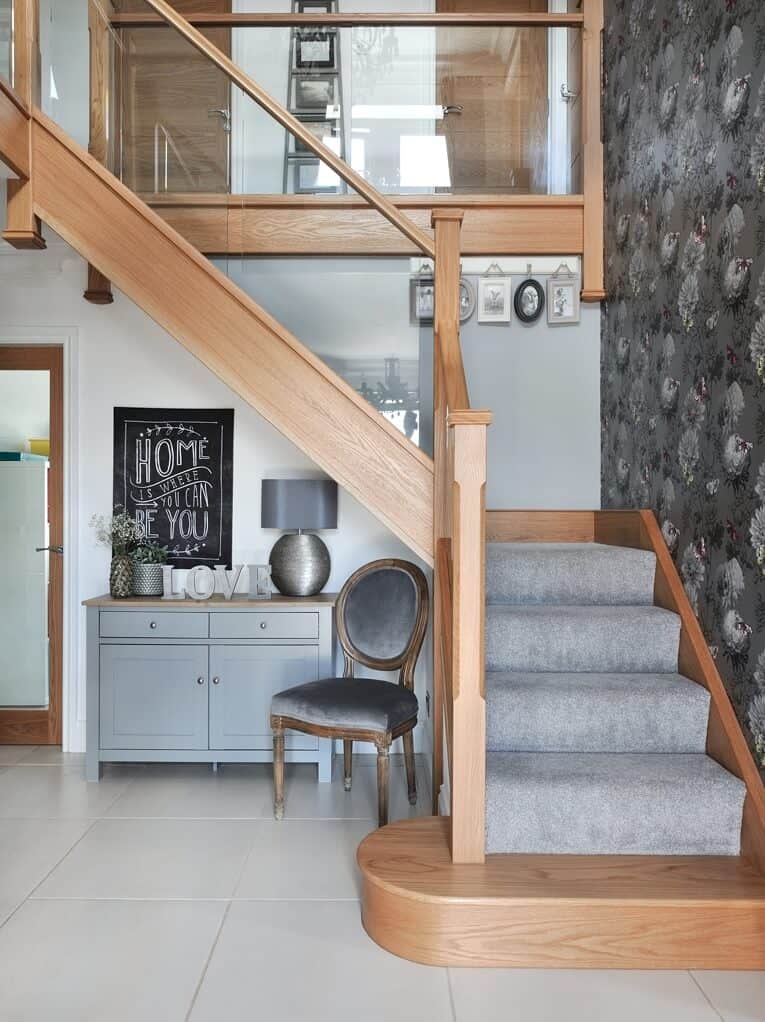 Modern entryway with wooden stairs and decor.