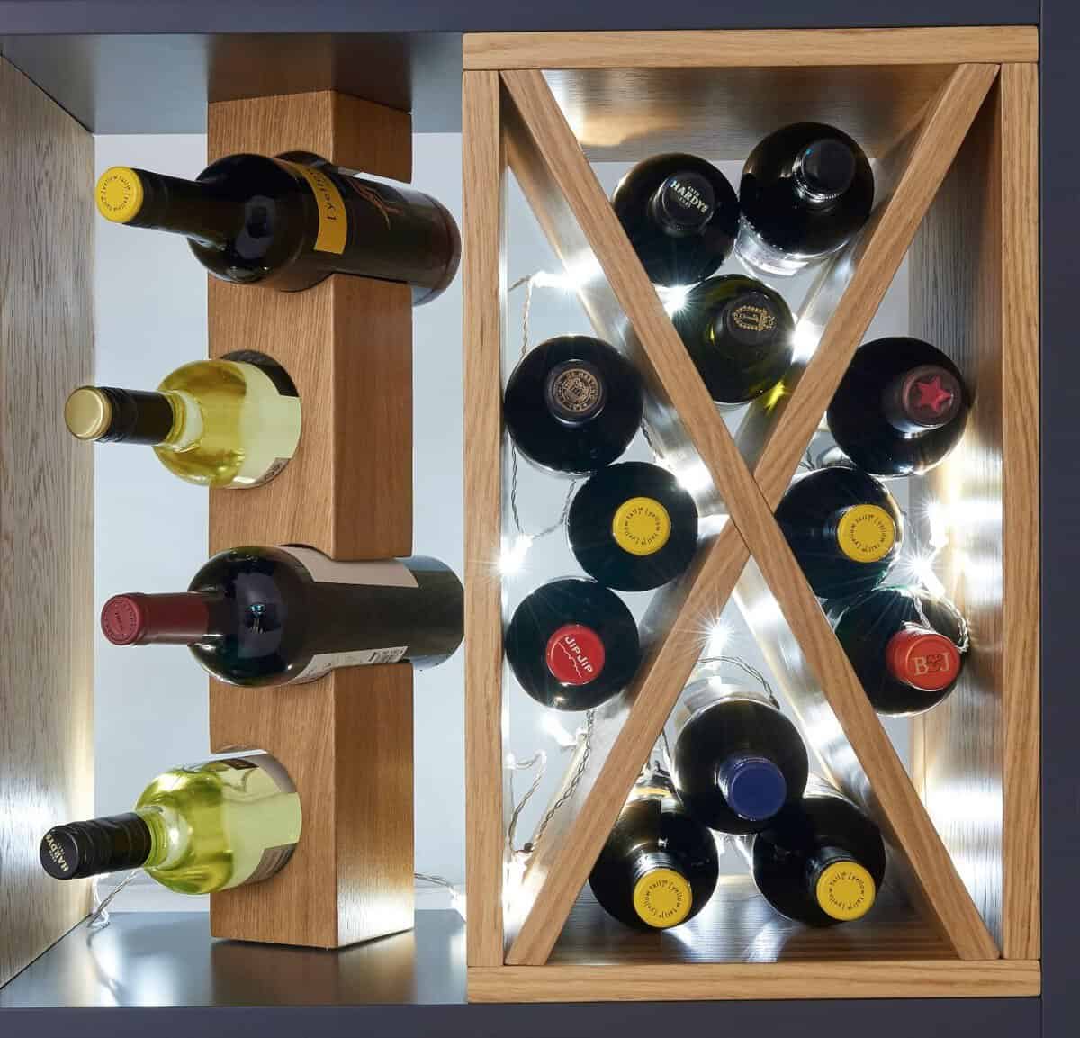Close-up of an illuminated oak wine rack with cross-shaped compartments and individual bottle supports.