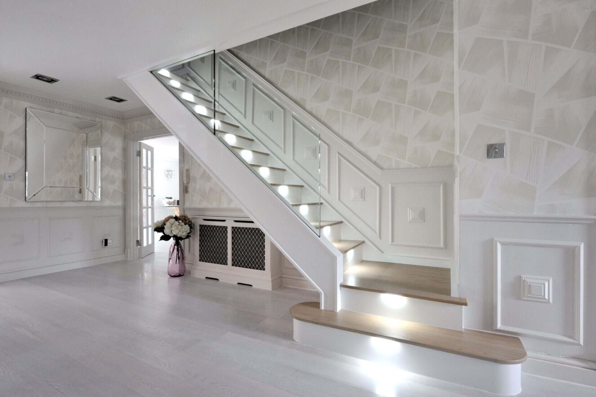 modern glass staircase in a spacious room with white walls and wooden accents