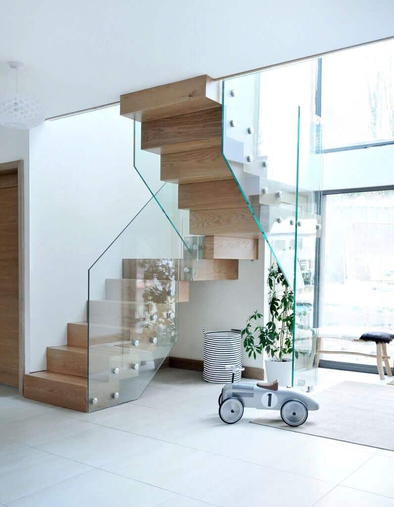Modern staircase with glass railing and toy car.